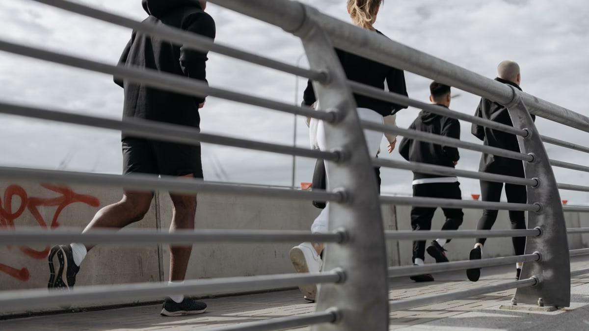 A group jogging outdoors on an urban bridge, promoting fitness and wellness.